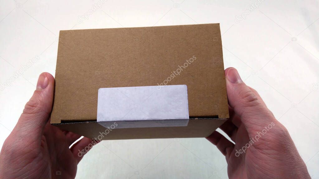 hands holding a small packaging cardboard box with white empty blank space and copy space.