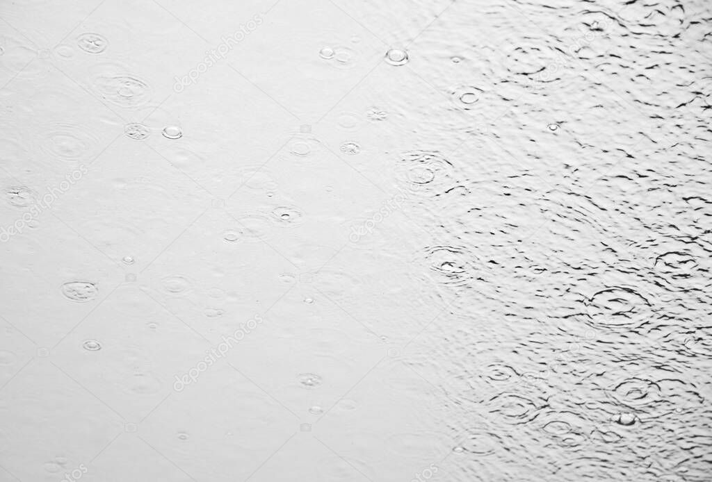 Monochrome image of the rain water drops splashes on the glass surface of Norway criuse ship window