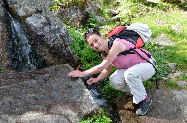 A hiker near the mountain brooklet — Stock Photo, Image