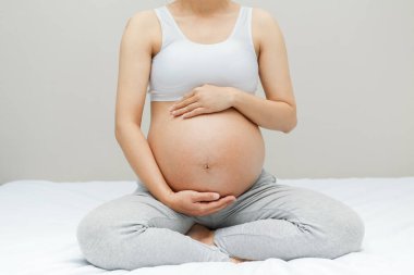 Hamile kadın koca karnına dokunuyor. Kapatın. Annelik, hamilelik, insanlar ve beklenti konsepti. Hamile kadın bebek bekliyor.