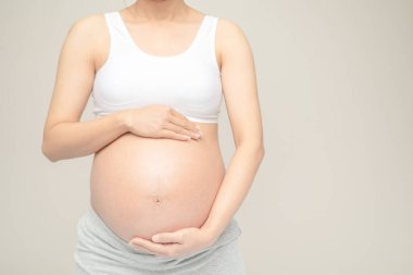 Hamile kadın koca karnına dokunuyor. Kapatın. Annelik, hamilelik, insanlar ve beklenti konsepti. Hamile kadın bebek bekliyor.