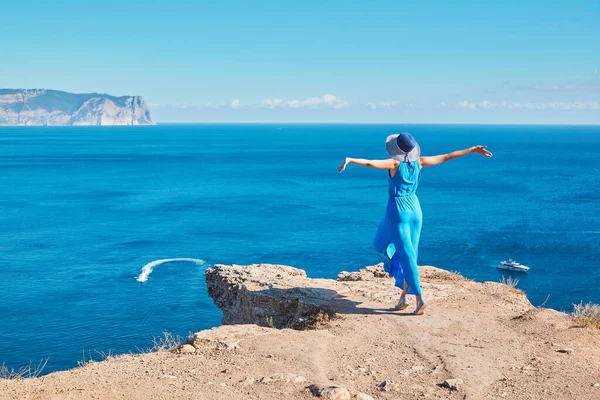 Excited lady enjoying sea view from cliff. Seascape and holiday idea. Travel time and relax time concept, copy space
