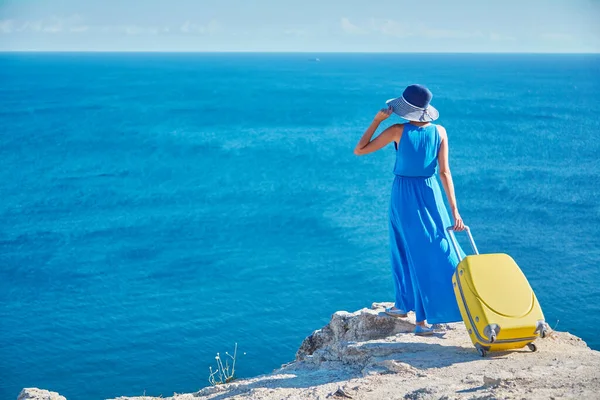 Concept de vacances et de voyage, espace de copie. Dame est arrivée en vacances avec une valise jaune. Météo ensoleillée et océan chaud. — Photo