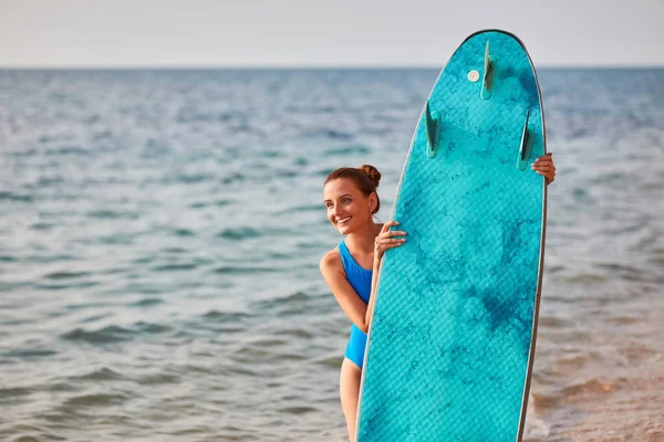 Сміється щаслива леді, готова до серфінгу в океані. Літня поїздка, серфінг-хобі, пригодницький час і концепція пляжного відпочинку. Копіювати простір — стокове фото