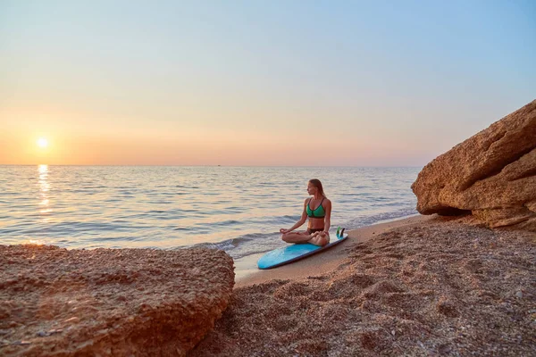 Γυναίκα που κάνει γιόγκα στην παραλία. Διαλογισμός στην παραλία το ηλιοβασίλεμα. Χαλαρώστε στη φύση. Ιδέα περισυλλογής και διαλογισμού — Φωτογραφία Αρχείου