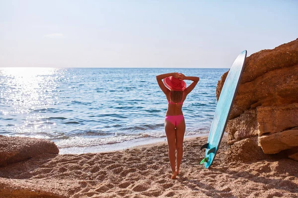 Женщина, стоящая сзади и смотрящая на море. Океан и песчаный пляж. Идея серфинга, летнего времени и путешествия в отпуск, пространство для копирования Лицензионные Стоковые Изображения