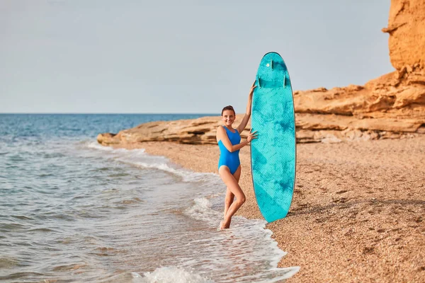 Dame en maillot de bain avec planche de surf. Passe-temps de surf, vacances d'été et idée d'aventure. Vue sur l'océan et plage de sable. Espace de copie Photos De Stock Libres De Droits