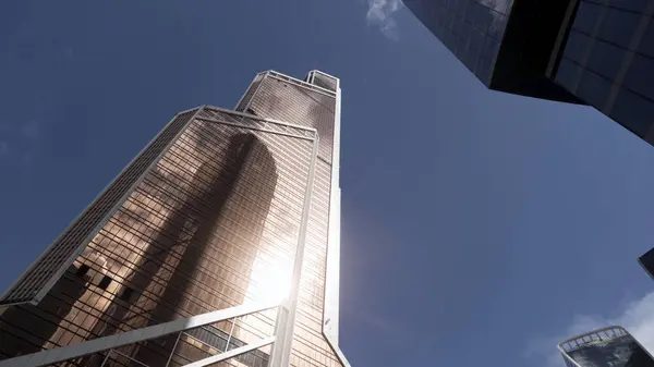 Nowoczesne biurowce ze szklaną fasadą. Akcja. Widok dolny nowego centrum biznesowego, nowoczesna dzielnica w dużym mieście na tle błękitnego nieba. — Zdjęcie stockowe