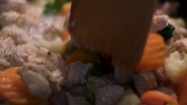 Kızarmış tavuk ve ahşap yemek çevirici ile sağlıklı sebzeler. Kavram. Kızartma havucu, brokoli, karnabahar ve tavuk parçaları, sağlıklı öğle yemeği kavramını kapat..