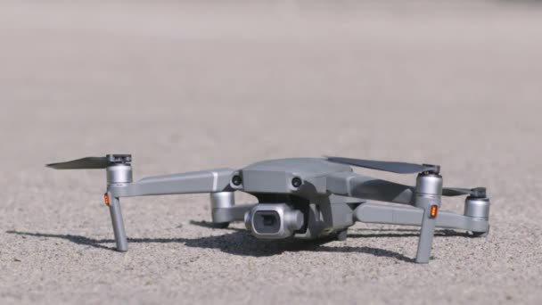 Primo piano del drone a terra. Azione. Drone professionale moderno per la fotografia aerea. Drone sul marciapiede è preparato prima del decollo — Video Stock