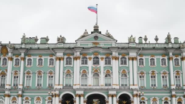 Fassade des Winterpalastes mit der Flagge Russlands. Handeln. Größte russische Architektur des Winterpalastes in Sankt Petersburg. Goldene Details und Statuen auf türkisfarbener Fassade eines historischen Gebäudes in Russland — Stockvideo