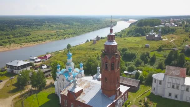 Vista superior de la Iglesia con torre sobre fondo de paisaje con río. Clip. Hermosa iglesia rusa en una pequeña ciudad situada en la llanura por río — Vídeo de stock