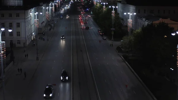 Vista aérea de uma rua da cidade com muitos carros dirigindo em uma estrada larga. Imagens de stock. Tarde da noite e o distrito central de uma cidade, conceito de vida urbana. — Fotografia de Stock