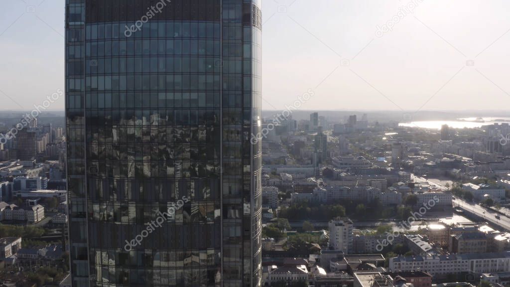Aerial view of Vysotsky skyscraper and Ekaterinburg city landscape, Russia. Stock footage. Flying close to the glass windows of a modern tall building.