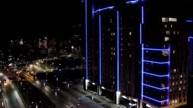Büyük şehir gece manzarası, gece hayatı kavramı. Stok görüntüleri. Gece şehir manzarasında birçok ışıkla mavi neon yüzlü muhteşem bir gökdelen..