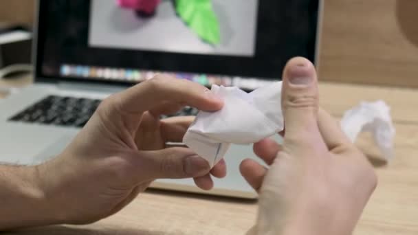 Mannelijke handen maken origami figuur van wit papier. Voorraadbeelden. De mens slaagt er niet in om een bloem van papier te maken zoals op een foto op een computerscherm, — Stockvideo