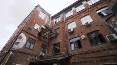 Arka plandaki eski tuğla binanın alt manzarası bulutlu gökyüzü. Başla. Eski kentteki kırmızı tuğla bina ofisler ya da işletmeler için kullanılıyor