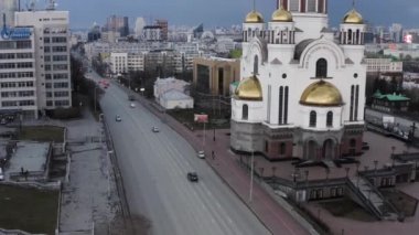 Kan Kilisesi ve Ekaterinburg şehri. Stok görüntüleri. Iset Nehri 'nin arka planında altın kubbeleri olan güzel caddenin ve muhteşem tapınağın üzerinde uçuyor..