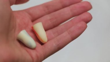 Sağlıklı uyku kavramı, ses geçirmez kulak tıkaçları. Kavram. Kız, kulak tıkaçlarını arka planda beyaz arka planda tutuyor..