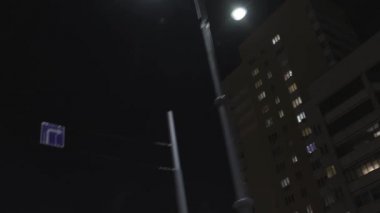 Gece caddesindeki vitrinin alt manzarası. Stok görüntüleri. Siyah gökyüzü arka planında konut evleri ve fenerler boyunca sürüş.