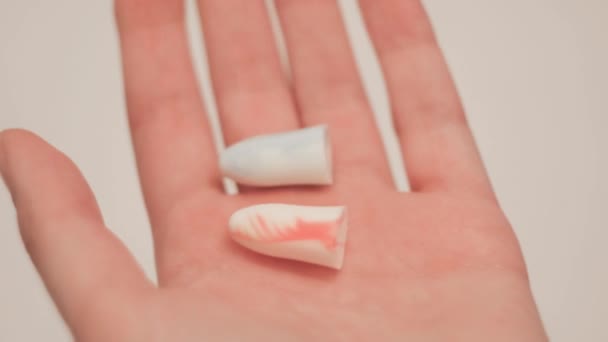 Close-up of ear plugs for ears in hand. Concept. Snoring keeps you awake, so woman suggests wearing earplugs. Earplugs for good nights sleep — Stock Video