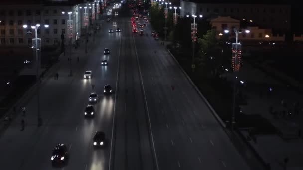 Vista aérea de una calle de la ciudad con muchos coches que conducen en una carretera ancha. Imágenes de archivo. Tarde en la noche y el distrito central de una ciudad, concepto de vida urbana. — Vídeo de stock