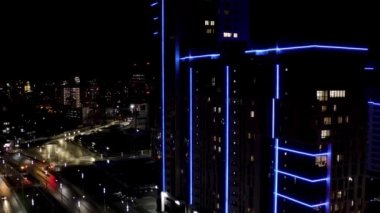 Büyük şehir gece manzarası, gece hayatı kavramı. Stok görüntüleri. Gece şehir manzarasında birçok ışıkla mavi neon yüzlü muhteşem bir gökdelen..