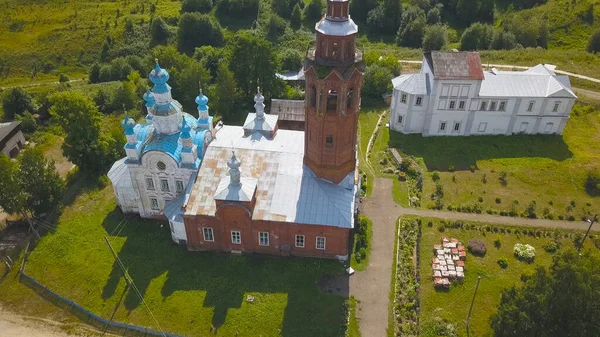 Horní pohled na kostel s věží na pozadí krajiny s řekou. Klip. Krásný ruský kostel v malém městě se nachází na rovině u řeky — Stock fotografie