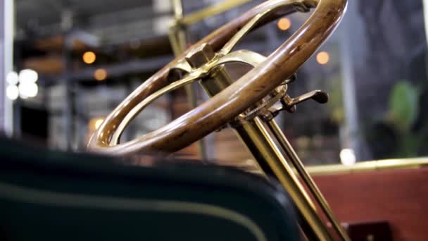 Close-up van klassieke auto details op de tentoonstelling. De media. Retro cabriolet auto en het gouden stuurmechanisme met een houten gepolijst wiel. — Stockvideo