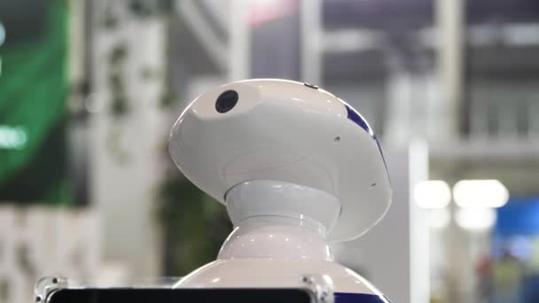 彼の頭の上にカメラで人型移動ロボットのクローズアップ.メディア。未来の技術を展示センターに移動する新しい技術ロボット. — ストック動画