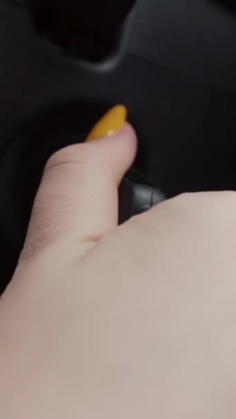 Primo piano di mano femminile avviare la sua auto moderna. Azione. Vista verticale di una donna con manicure gialla brillante che gira una chiave all'interno della serratura di accensione, concetto di guida e trasporto. — Video Stock