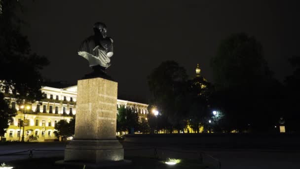 Gece parkında büstü olan anıt. Başla. Geceleyin aydınlatılan tarihi binaların arka planında Park 'taki büstün görüntüsü. Büyük insanların anıtlarıyla dolu tarihi park. — Stok video