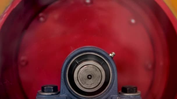 Close-up de mecanismo de metal rotativo, conceito de indústria pesada e construção. Mídia. Vista lateral do trommel em forma redonda em movimento de cor vermelha. — Vídeo de Stock
