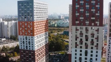 Şehirdeki çok renkli yerleşim yerlerinin en üst görüntüsü. Başla. Modern konut kompleksinin üst katlarından şehrin güzel manzarası açılıyor. Güneşli bir günde parlak konut kompleksi