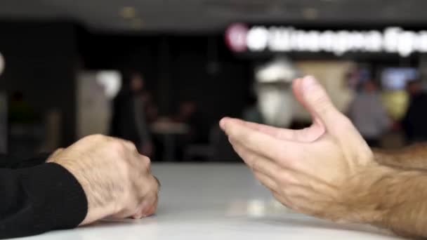 Sluiten van een tafel en handen van twee mannen die een gesprek of gesprek hebben. De media. Onderhandelen over twee mannen met hun handen met gebaren en emoties. — Stockvideo