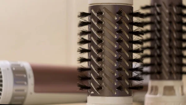 Herramientas de peluquería y accesorios aislados sobre fondo blanco. Concepto. Primer plano de la mano de la mujer que sostiene el cepillado de secador de pelo giratorio. —  Fotos de Stock