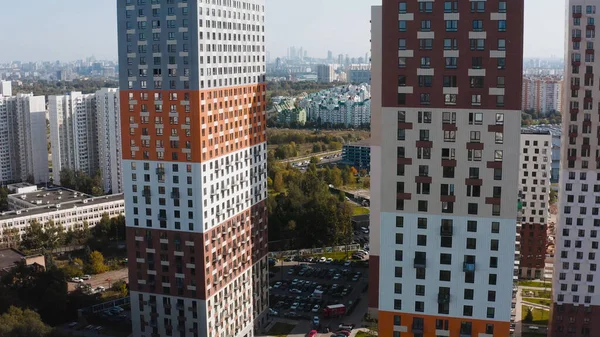 Blick von oben auf bunte Wohnkomplexe in der Stadt. Handeln. Wunderschönes Stadtpanorama eröffnet sich aus den oberen Etagen eines modernen Wohnkomplexes. Helle Wohnanlage an sonnigem Tag — Stockfoto