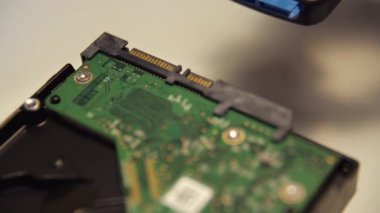 Bir çipi bir adaptör vasıtasıyla dış bir cihaza bağlamaya çalış. Medya. Bir adaptörü bir mikro devreye bağlayan erkek el, nöronet ve bilgisayar teknolojisi kavramı.