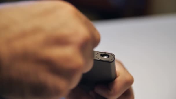 Detailní záběr ruky při vkládání nabíječky USB kabelu do přenosné napájecí banky. Média. Close up of mans hand inserting a cable into charger. — Stock video