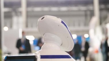 İnsanların arka planında gelecekçi robot. Medya. Fütüristik robotların başı teknoloji sergisine bakıyor. Robotlarla gelecek