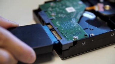 Erkek eliyle dış adaptöre bağlanan yeşil elektronik devre kartını kapat. Medya. Modern teknoloji ve mühendislik kavramı.