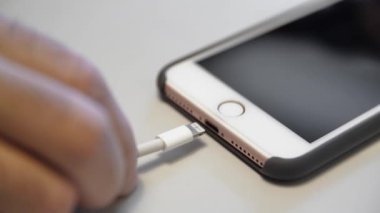 Telefonuna şarj olmaya yakın çekim. Medya. Markalı telefon için özel şarj konnektörü. Telefonunu kabloyla şarj ediyorsun.