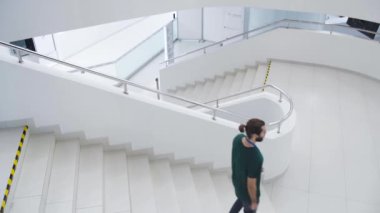 Beyaz binada rozetli adamlar var. Medya. Rozetli genç adamlar beyaz merdivenlerden çıkıyorlar. Rozetli genç çalışanlar beyaz binaya giriyor.