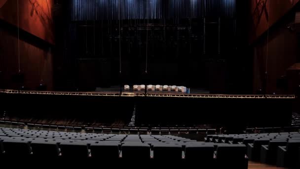 Filas vacías de sillones en un salón oscuro para una conferencia o un foro. Medios. Sala de conciertos vacía antes de un evento público masivo con muchas sillas vacías y cómodos sillones beige en el escenario. — Vídeo de stock