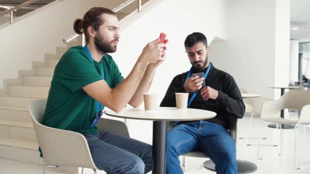 I lavoratori si siedono su telefoni a pranzo in caffè di ufficio. I media. Giovani impiegati siedono sui loro telefoni durante la pausa. Dipendenza dal telefono tra i giovani impiegati — Video Stock
