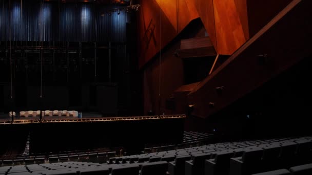 Grande salle de théâtre avec scène et balcons. Les médias. Vue depuis les rangées arrière de la salle de théâtre sombre avec un faible éclairage. Bel intérieur moderne de salle de théâtre avec scène — Video