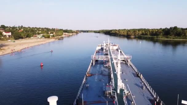 Vista aérea do navio comercial de carga navegando pelo rio cercado por floresta verde em um dia ensolarado de verão. Filmagem. A barcaça vai ao longo do rio no fundo de campos, floresta e banho — Vídeo de Stock