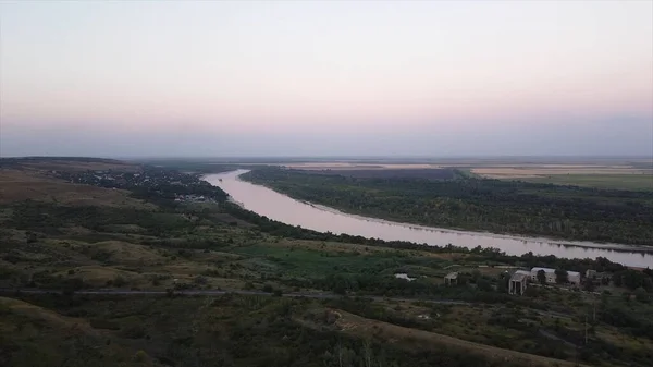 Zomer landelijk landschap met een klein dorp, bos en rivier, uitzicht vanuit de lucht. Beelden. Natuurlandschap met weelderige groene weiden en landbouwgronden, een rivier en een dorp bij zonsondergang. — Stockfoto