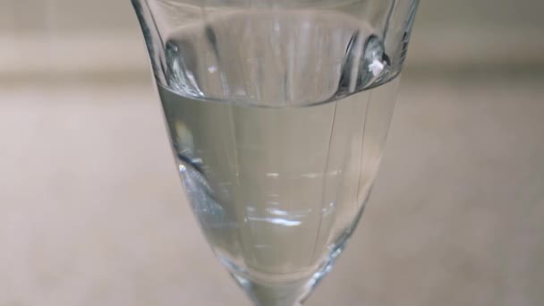 Primo piano di gocce di vitamine liquide che cadono nell'acqua limpida in un bicchiere. Concetto. Assunzione di vitamine durante il coronavirus covid 19 pandemia, prevenzione delle malattie. — Video Stock