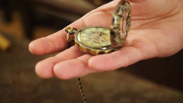 Man holds antique hand watch. Stock footage. Close-up of beautiful hand watch with patterns on lid. Close-up of man looking at vintage hand-held watch